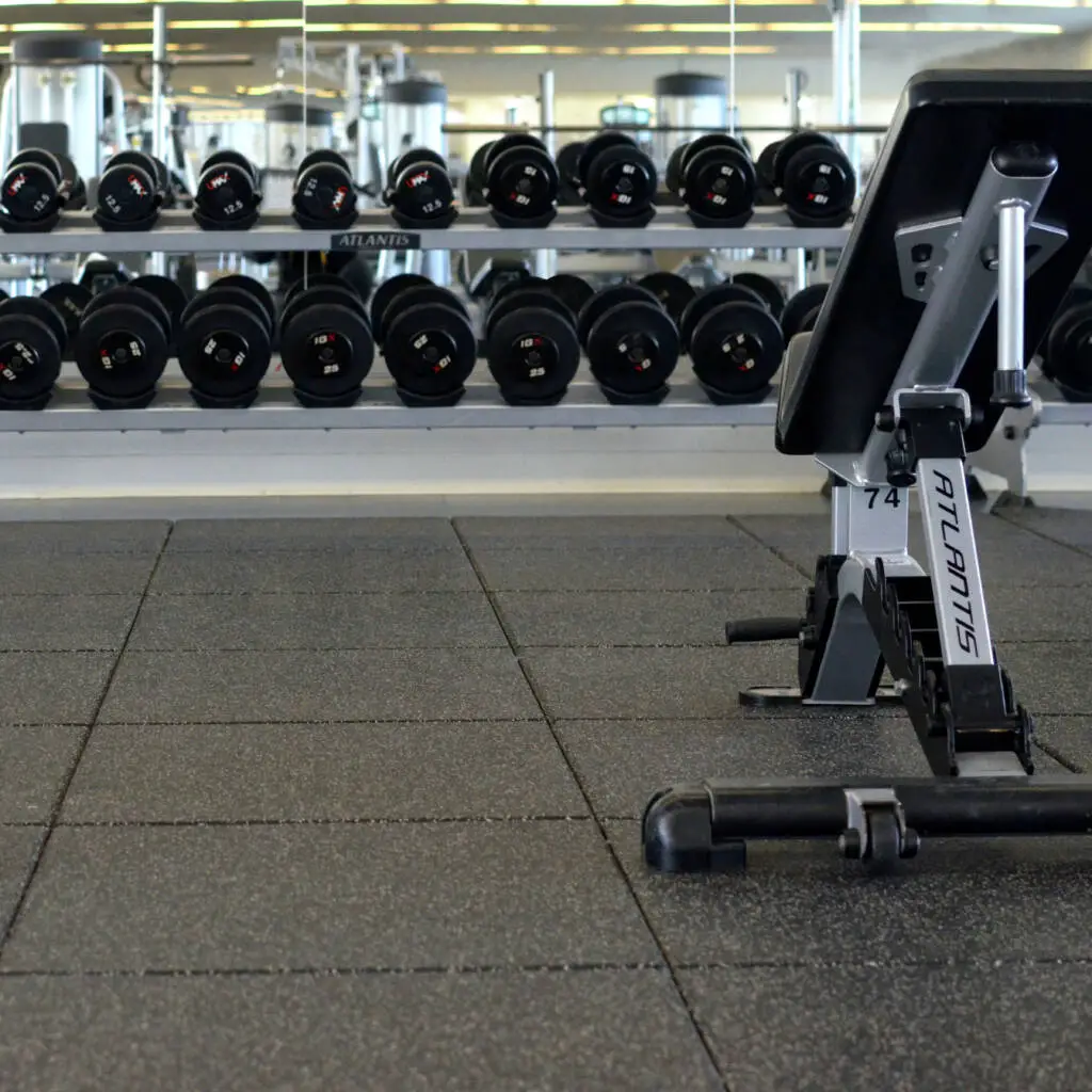 Rubber tiles in fitness center with benches on the surface